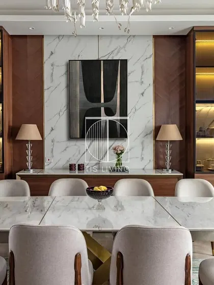 A head-on view of the dining set, showcasing the ten-seater table with its sculpted brass base. The surrounding display cabinets with internal lighting were also crafted by us to complete the room.