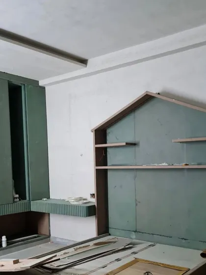 The work-in-progress photo of the kids' room, showing the house-shaped bed frame and shelving being built on site, ready to be turned into a dream space.