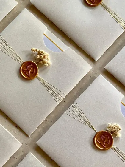These beautiful flat envelopes were created for a private home ceremony. The design is minimal and elegant, featuring a simple thread wrap, a custom wax seal, and a tiny sprig of dried flowers.