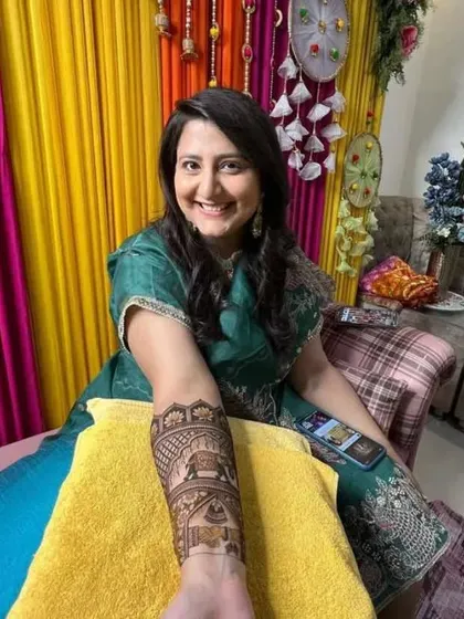 Another shot of a smiling client with her traditional bridal henna. The design includes palace scenes and elephants, perfect for a royal wedding theme.