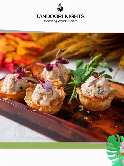 Savory tartlets filled with a creamy mixture and topped with micro-herbs, presented on a wooden tray. These bites are a testament to our craft.
