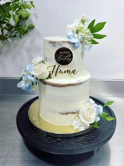 A pretty cake for a pretty human. This two-tiered semi-naked cake is filled with our signature three-berry compote and lemon curd, and decorated with fresh flowers for a beautiful birthday celebration.