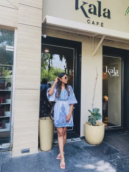 A slightly different pose in the same blue printed dress, showing how a simple outfit can look great from all angles.