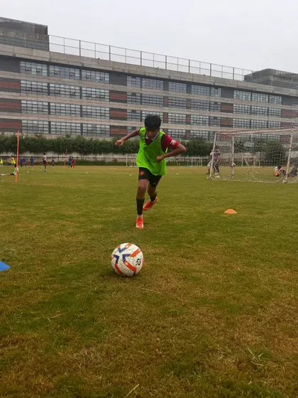 A young athlete running with the ball, building both speed and ball control.