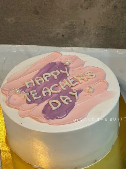 A simple Teacher's Day cake with a pink and purple brushstroke design.