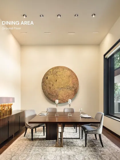 In this Vasant Vihar residence, the dining area is anchored by a monumental piece of art. The design is intentionally minimalist to allow the artwork to command the space, creating a gallery-like experience for everyday dining.
