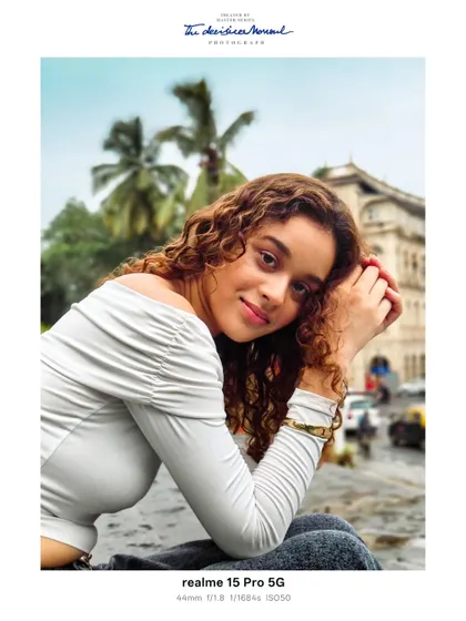 A close up portrait with the bustling Mumbai streetscape softly blurred in the background. The warm tones and the subject's gentle smile create a welcoming and authentic feel.