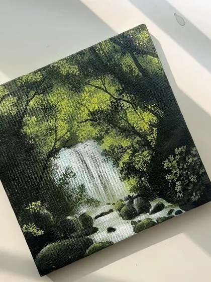 Lost in the woods. This is a finished acrylic painting of a waterfall hidden deep in a forest, with sunlight filtering through the canopy. It’s a piece that invites you to step into a calmer world.