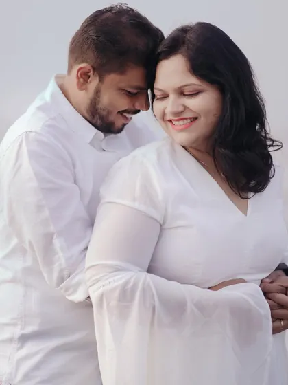 A beautiful, soft-lit portrait from a beach pre-wedding shoot. The gentle embrace and their happy expressions make this a heartwarming photo.