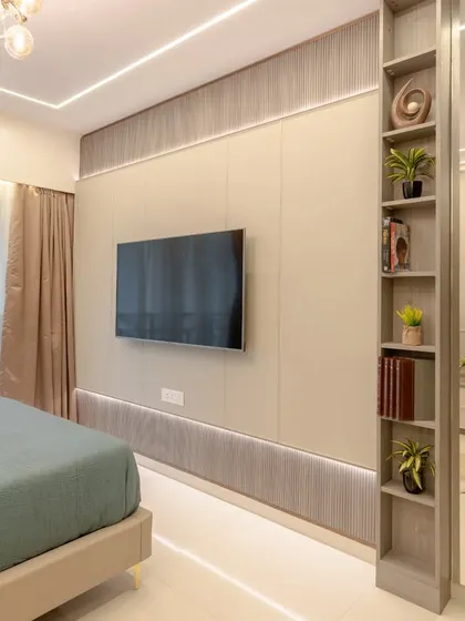 The TV wall in the Urban Elegance bedroom, with a slim bookshelf partition that cleverly separates the sleeping area from a small vanity space.