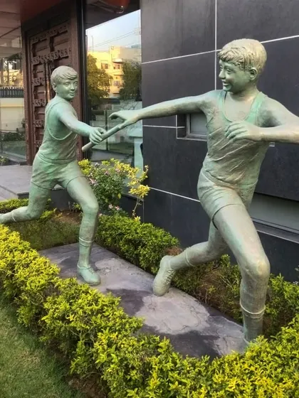 This life-size FRP sculpture shows two young runners in a relay race, symbolizing teamwork and momentum. It's an ideal piece for schools or sports complexes.