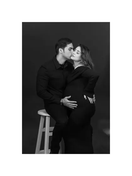 A tender kiss shared between the expecting couple. This black and white image is full of romance and emotion, a beautiful memory from their dramatic studio maternity session.