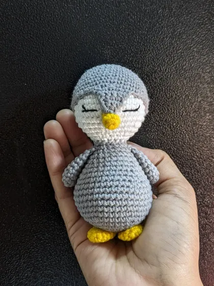 The simple sleepy penguin against a dark background, highlighting its form.