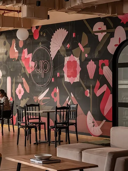 The pantry area is designed with two distinct moods. One side is soothing and calm for quiet breaks, while the other features this "Up"beat custom wallpaper, reflecting the brand's identity and adding a playful touch to the workspace.