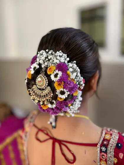 This floral bun is a work of art. I used a mix of colorful flowers and a traditional jhoomar accessory to create a unique and vibrant look for the bride's big day.