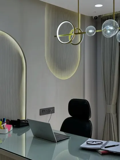 The final result of an office cabin, featuring backlit arched wall panels and a modern globe chandelier. This space is both professional and stylish.