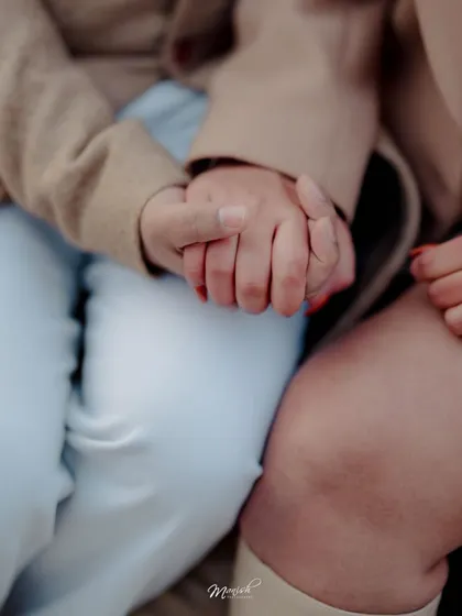 A close-up on their intertwined hands, a simple yet powerful symbol of their connection and the promise of their future together.