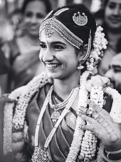 A radiant smile from the bride, captured in a classic black and white portrait during her wedding ceremony.