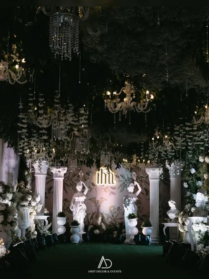 A romantic and dramatic entranceway designed to feel like a secret garden at night. The combination of lush greenery, classical statues, and dozens of sparkling chandeliers creates an immersive, magical experience for guests.