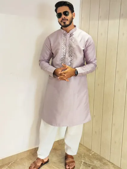 A full-length view of the client in the lavender mirror-work kurta, showing how it pairs with a white salwar and traditional footwear.