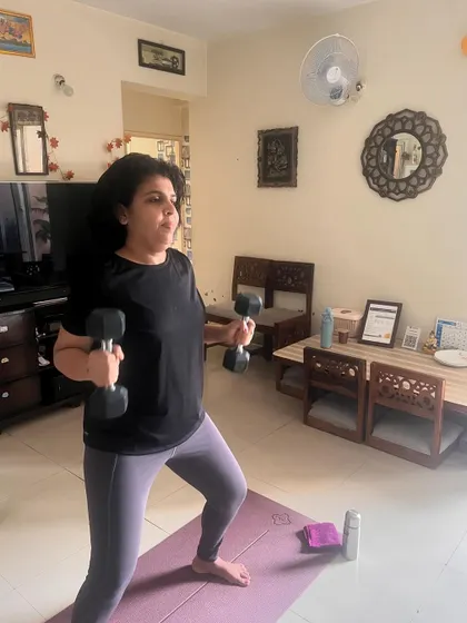 A duplicate of the previous image, showing a client focused on her form during bicep curls, a key element of our strength training philosophy.