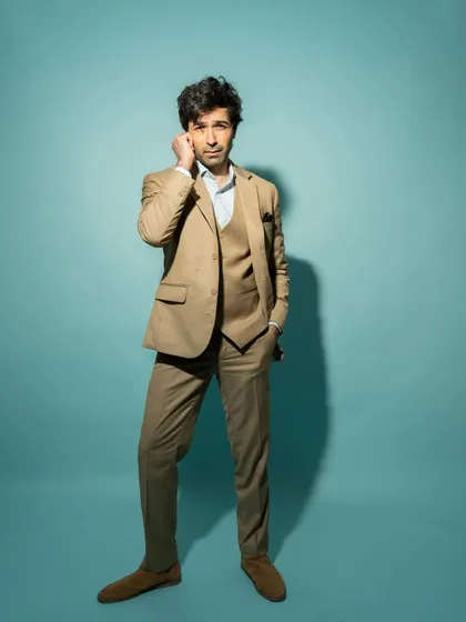 A full-length shot from the same session, showing the complete suit and a confident, relaxed pose.