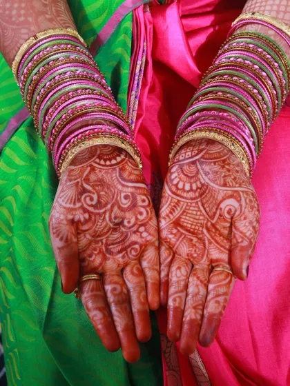 A clear, top-down view of a bride's hands, showing the beautiful and complex mehndi design.