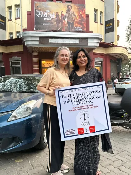 With a fellow activist holding a placard that reads "Your Vote Is Your Voice". We organized this drive outside a cinema hall to remind people that their vote is more important than any weekend entertainment.
