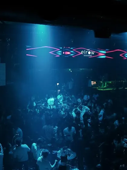 A wide shot of the dance floor at Elrow, bathed in cool blue light. The atmosphere is just as important as the playlist.
