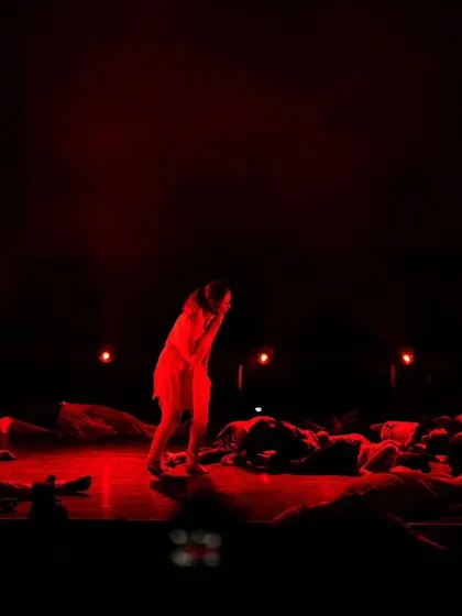 A dramatic and somber scene from 'Inquilab,' using stark red lighting to create a powerful emotional impact.