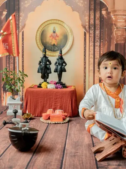 An expressive shot where the baby looks up with wonder. The warm, temple-like backdrop creates a beautiful atmosphere for this traditional Maharashtrian photoshoot.