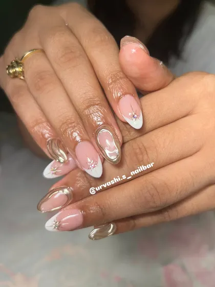 This festive design combines a classic white French tip with modern gold chrome swirls and tiny star-shaped rhinestone accents. It's a glamorous and sophisticated look.
