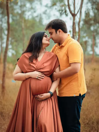 An intimate moment between an expecting couple in a beautiful outdoor setting. The warm colors of her dress and the natural surroundings are a perfect match.