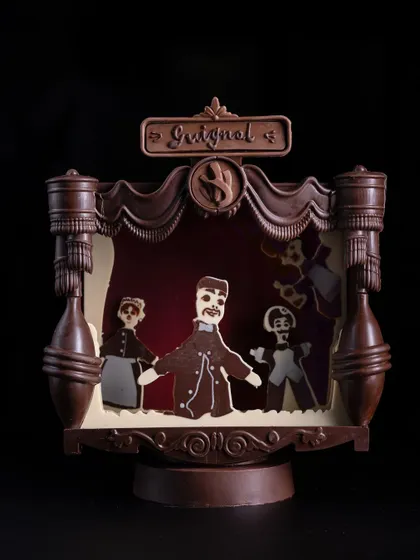 A detailed look at the chocolate puppet theater component of the Guignol showpiece, showcasing intricate molding and character work.