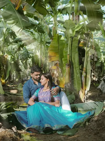 A romantic portrait of the couple sitting together amidst the greenery of the plantation.