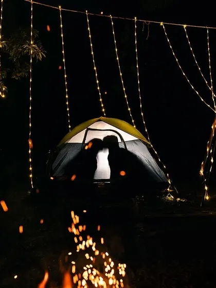 A magical silhouette of a couple inside a tent, surrounded by fairy lights. This cozy and intimate shot is perfect for capturing a sense of adventure and romance.