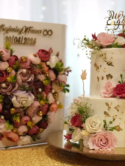 This engagement cake was designed to match the couple's beautiful floral invitation box. The two-tiered cake features a delicate buttercream finish, edible gold leaf, and carefully placed sugar flowers to create a cohesive and romantic theme.