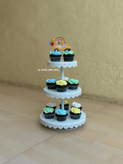 A fun set of Cocomelon-themed cupcakes on a three-tier stand, showing how we can match cupcakes to a party's theme.