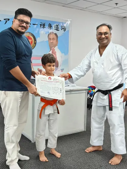 A young boy earns his orange belt. I ensure that every student's progress is acknowledged, reinforcing the value of their effort and practice.