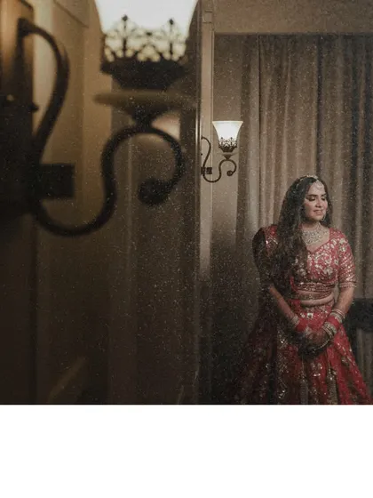 This portrait uses soft, ambient lighting to create a warm and dreamy atmosphere. The bride's gentle pose and the elegant interior setting combine for a timeless and romantic photograph.