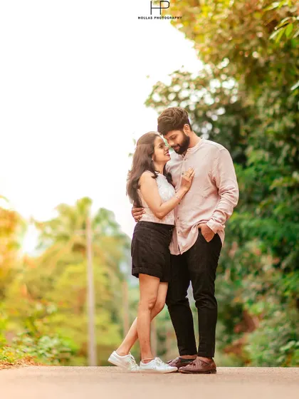 A sweet, romantic portrait of a couple standing on a country road, surrounded by lush greenery. Their gentle interaction and the soft light make for a beautiful, natural photo.