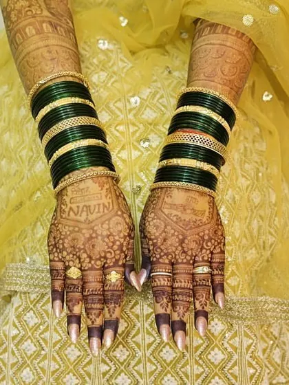 The back of the hands, showing the stunning stain of the bridal mehendi. The personalized name is clearly visible.