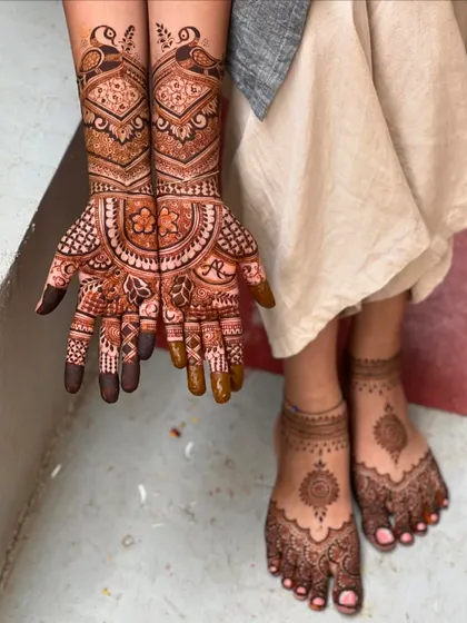 A complete semi-bridal look, showing the coordination between the hand and feet mehendi. The feet feature a simple but elegant mandala design.