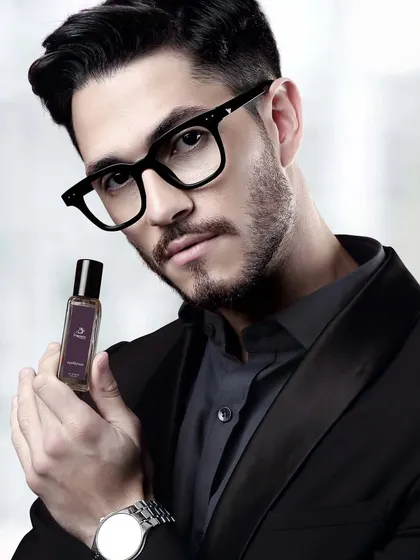 A model in a suit jacket holds a perfume bottle, blending professionalism with personal style for a corporate fragrance line.