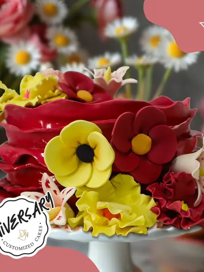 A vibrant and blossoming cake for Mr. and Mrs. Gaur's anniversary in Lado Sarai. The bold red and yellow sugar flowers create a joyful and festive look for their celebration.