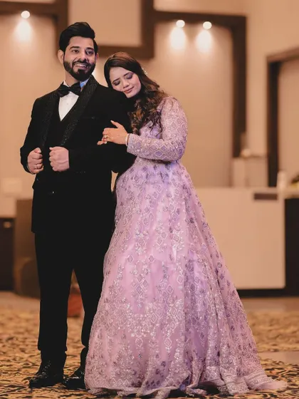 A stylish and classic portrait from a reception. The bride rests her head on the groom's shoulder as he stands confidently in his tuxedo. This pose is elegant and timeless, perfectly capturing the formal yet intimate feel of the celebration.