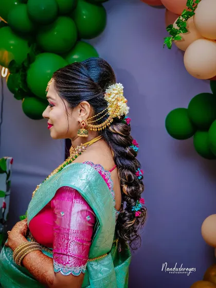 A profile shot highlighting the mother-to-be's intricate traditional hairstyle with fresh flowers, a beautiful detail from her baby shower look.