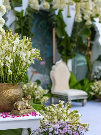 A detail shot of the ceremony space, with a brass vase of white tuberose and a small, traditional elephant statue.