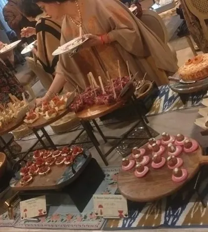 Another shot of guests enjoying the high-tea buffet. The spread is designed to offer a wide variety of flavors and textures in an elegant, easy-to-eat format.