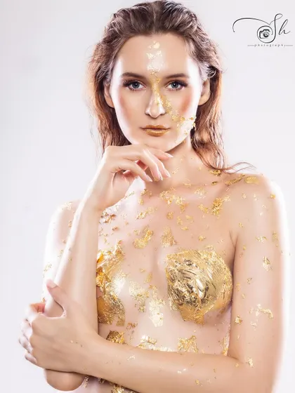 A high-fashion portrait of a model with gold foil makeup, showcasing our ability to execute complex creative concepts with professional results.